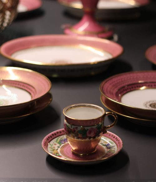 Delicate porcelain tableware with intricate floral designs on display.